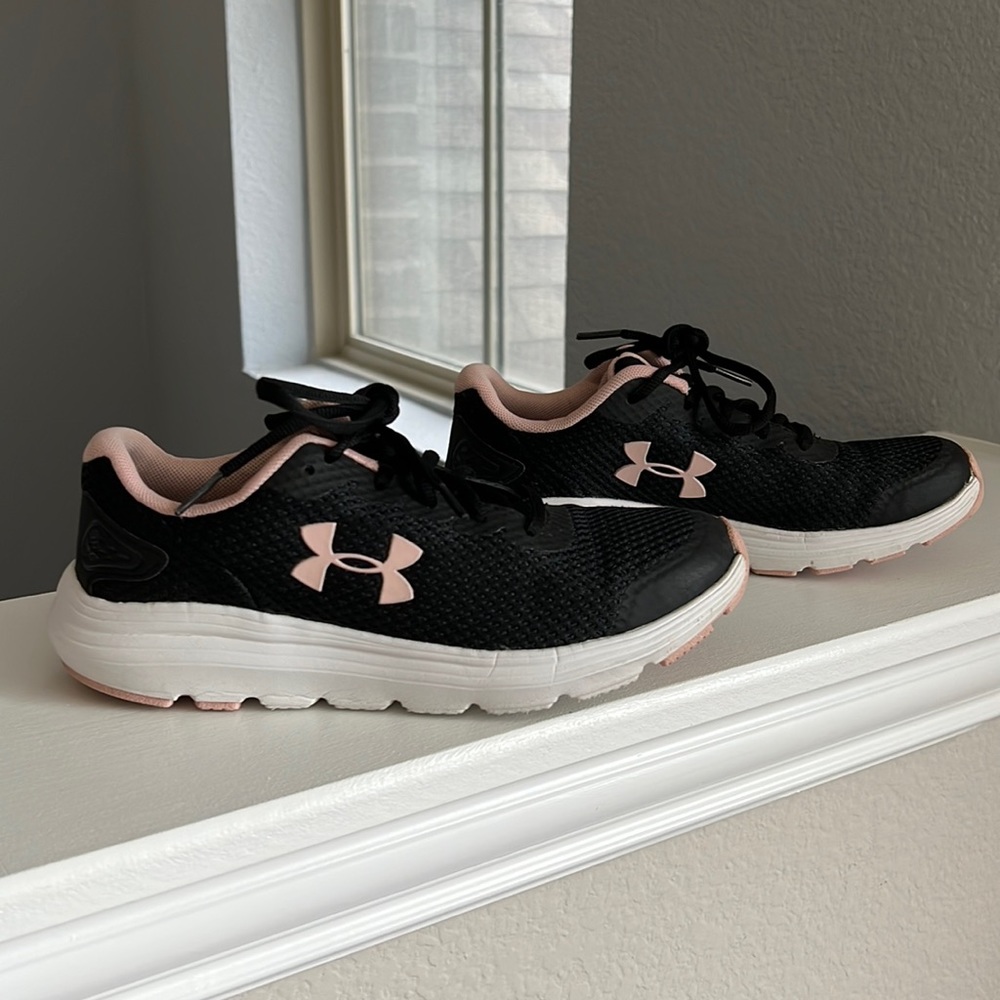Pink, white and black Under Armour Surge tennis shoes